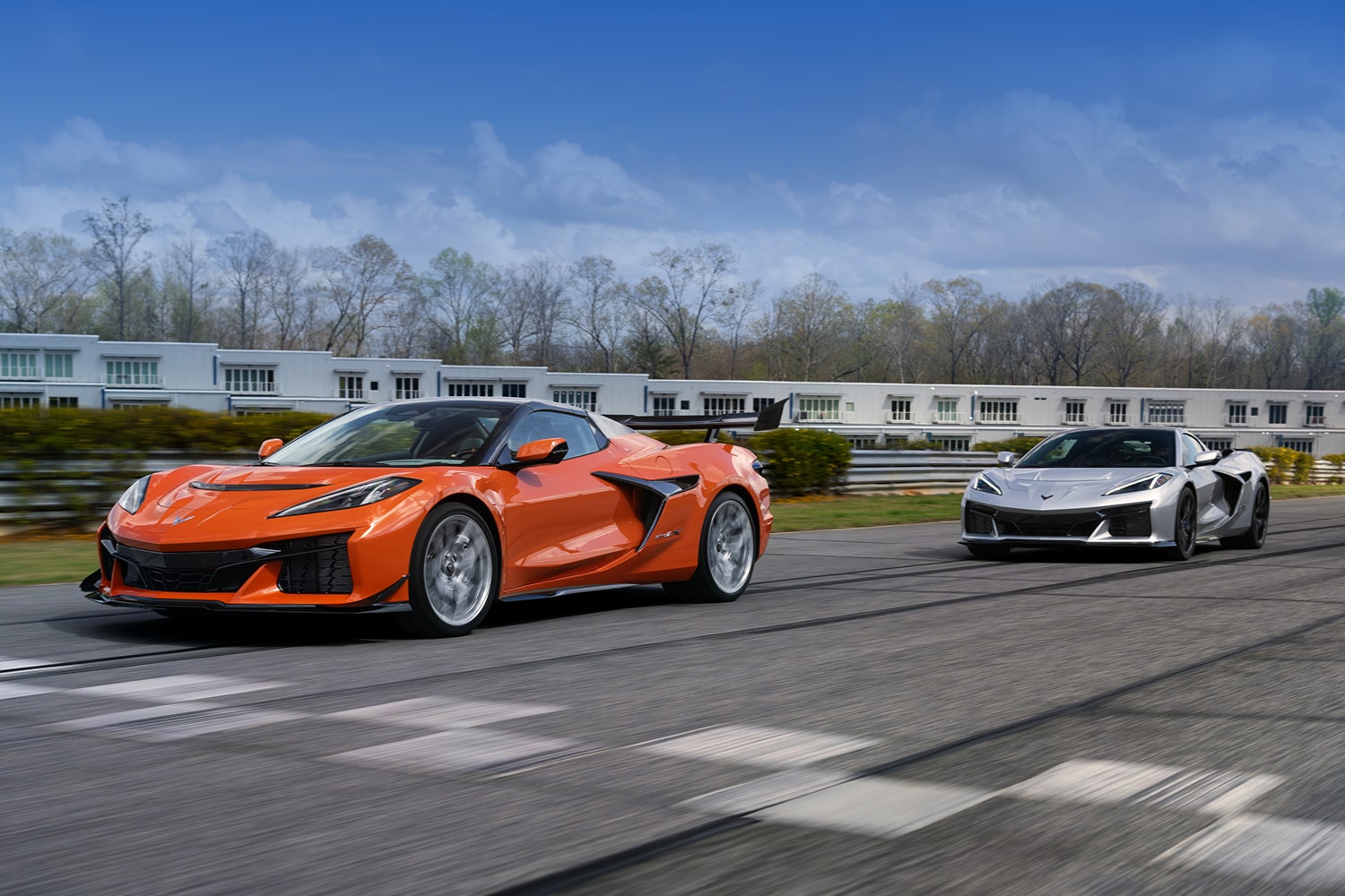 Two Chevy Corvettes Driving Down a Road.