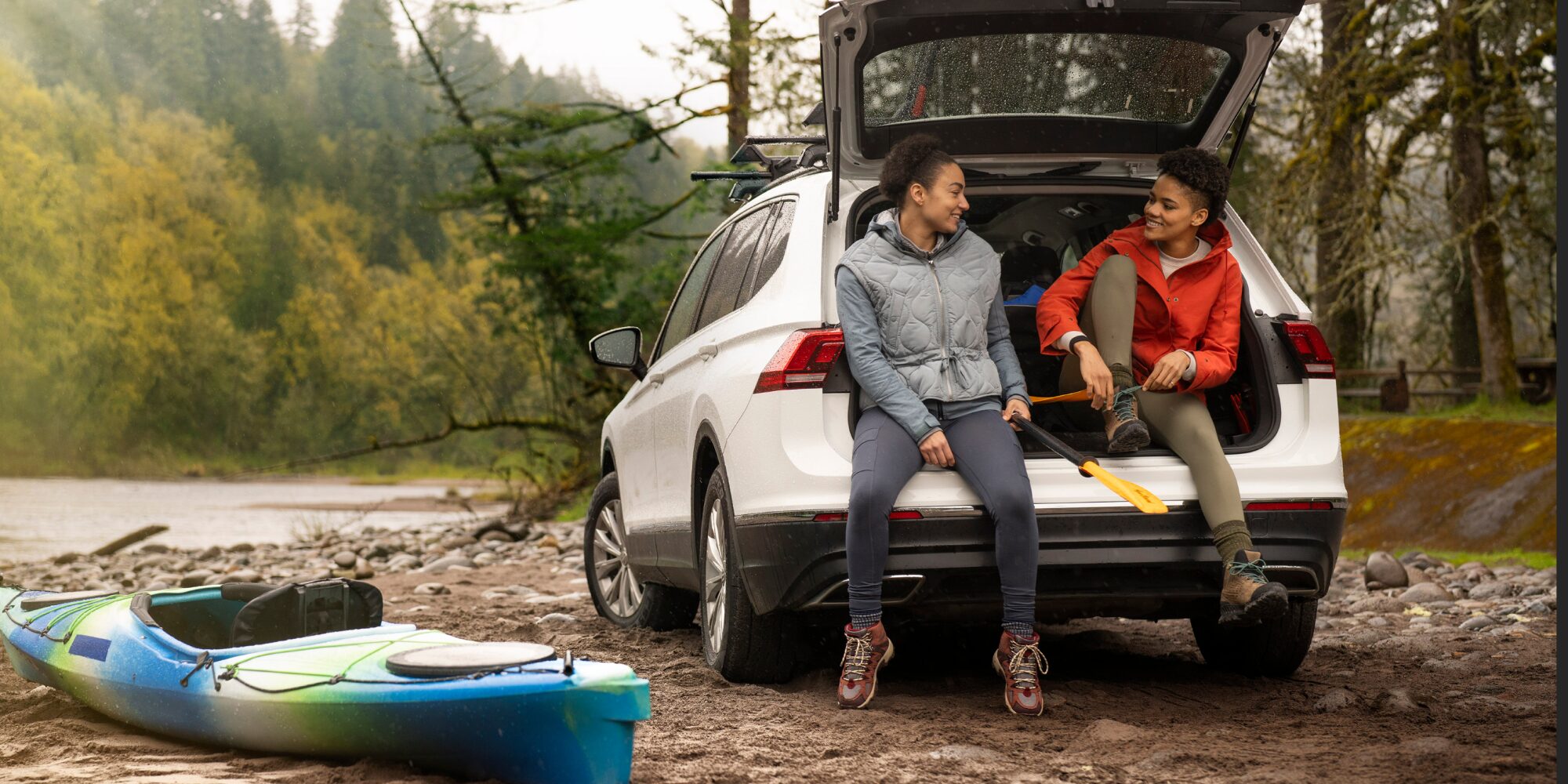 A Couple Sitting in the Trunk of their Chevy SUV at a Campsite