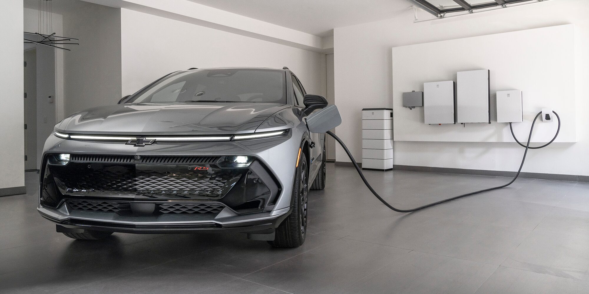 2026 Chevy Equinox EV Plugged into a Wall Charger in a Garage