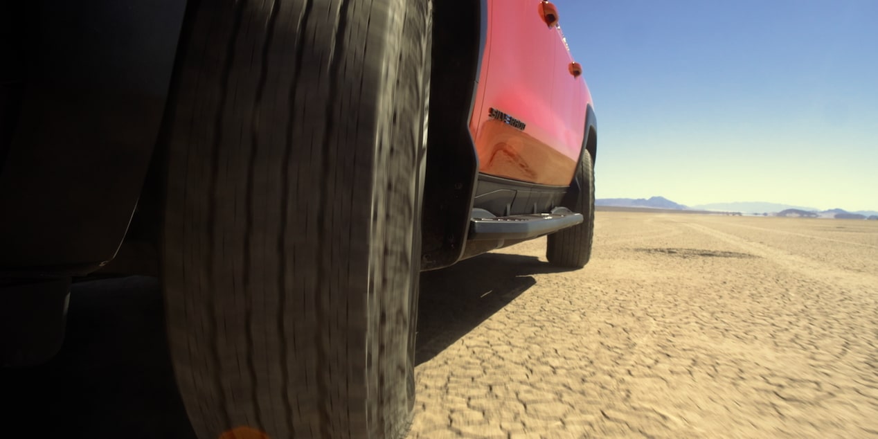 Close-Up View of Wheels on the 2026 Chevy Silverado EV Driving on Western Terrain