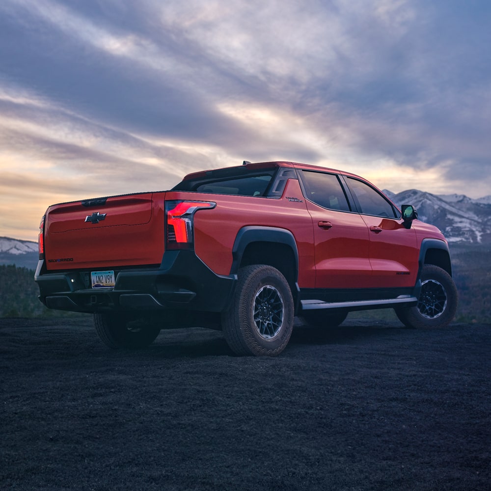 2026 Chevy Silverado EV Parked at Dusk with Mountainous Terrain in the Background