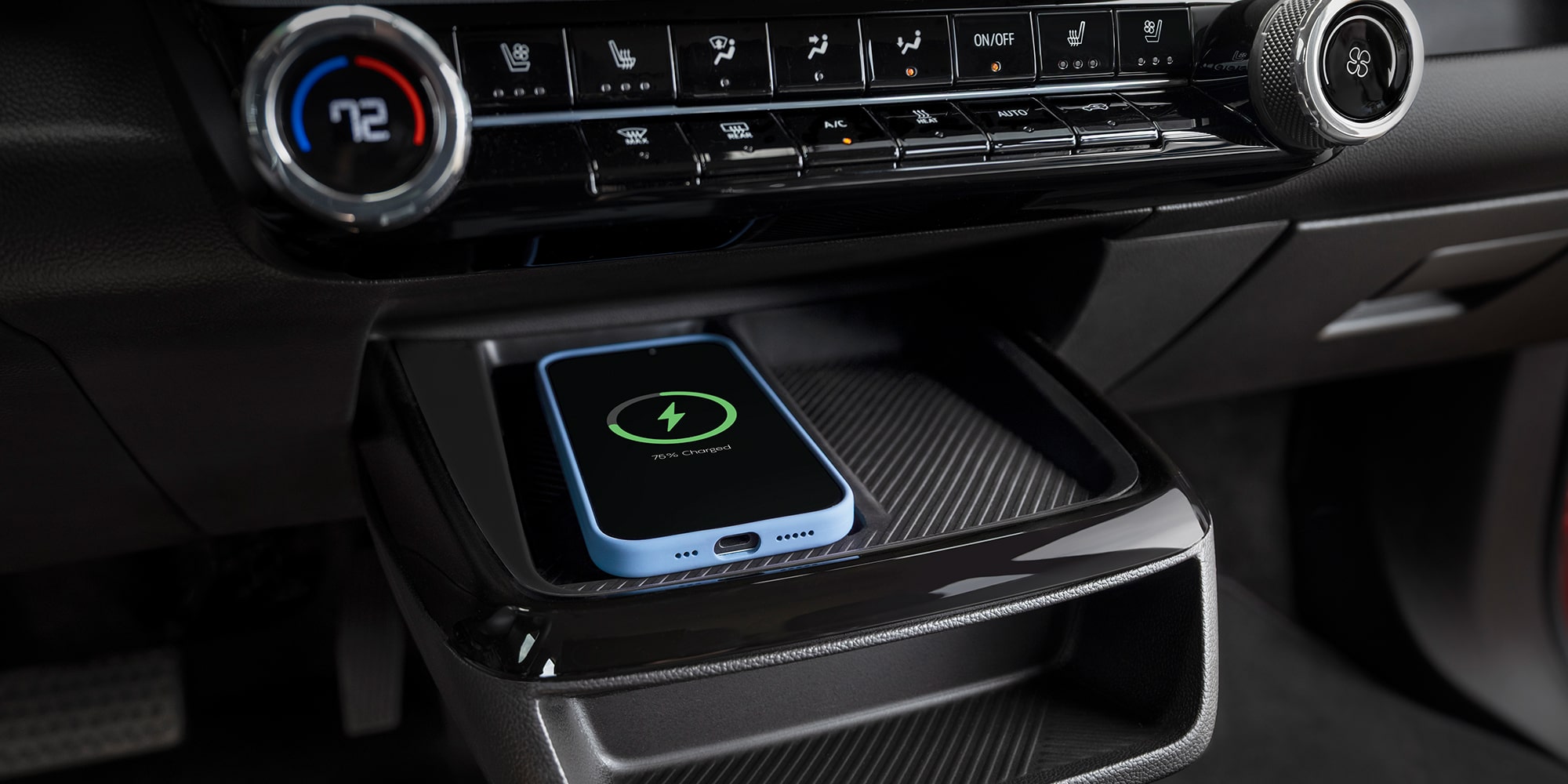 The Interior Center Console of a 2027 Chevrolet Bolt, Showing a Light Purple Smartphone Resting on the Wireless Charging Pad.