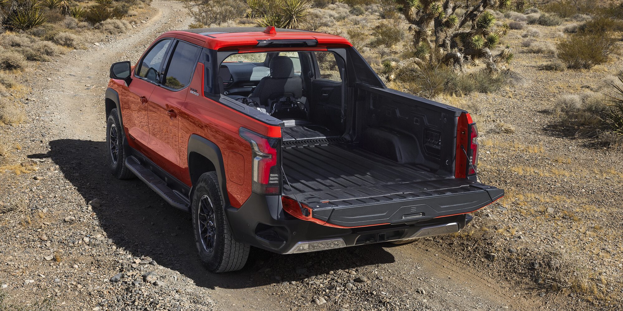 Rear View of Orange 2026 Silverado EV with Tailgate Down Revealing Ample Cargo Space and Versatility