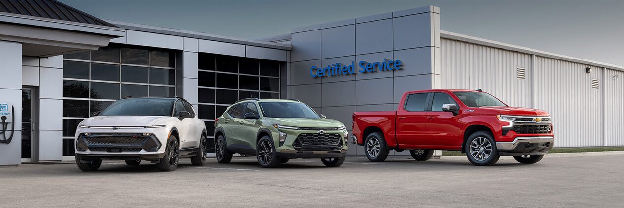 Three Chevrolet Vehicles Presented in Front of a Certified Service Garage