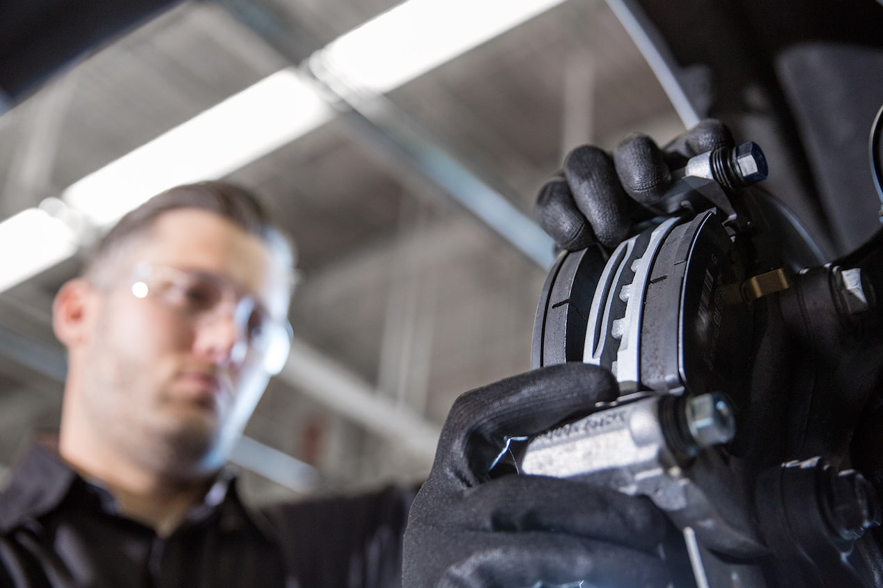 A Mechanic Is Drilling Screws to Attach a Wheel to a Vehicle