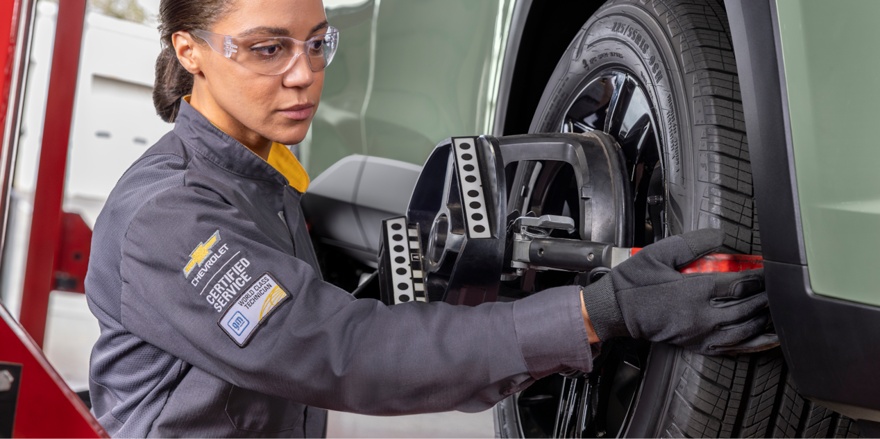 A Mechanic Using Tools to Replace a Tire on a Chevrolet Vehicle