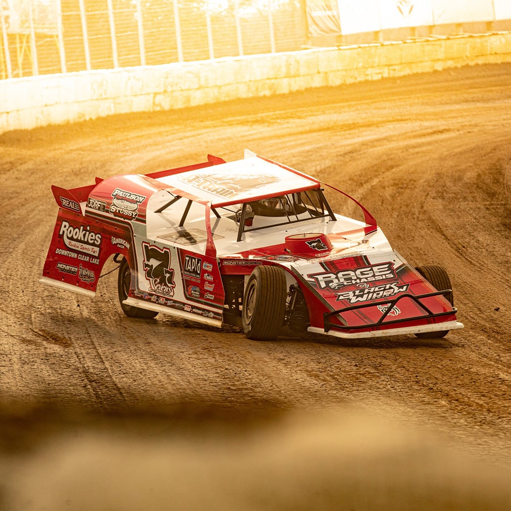 A Race Car Making a Turn on a Dirt Track