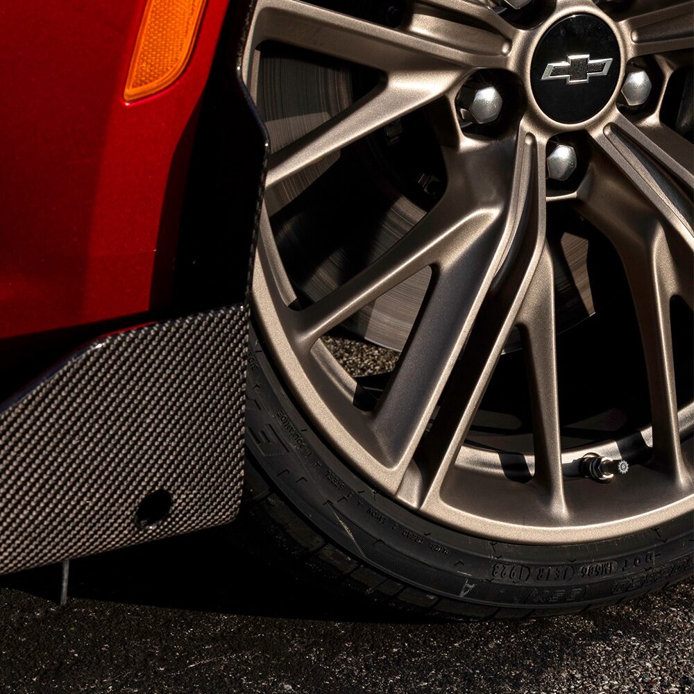 Close-up of a Chevrolet Camaro Wheel with a Metallic Rim and Tire against the Pavement