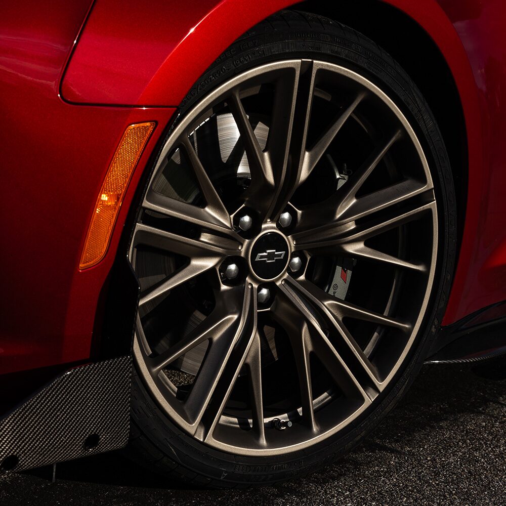 Close-up of a Chevrolet Camaro Wheel with a Metallic Rim and Tire against the Pavement