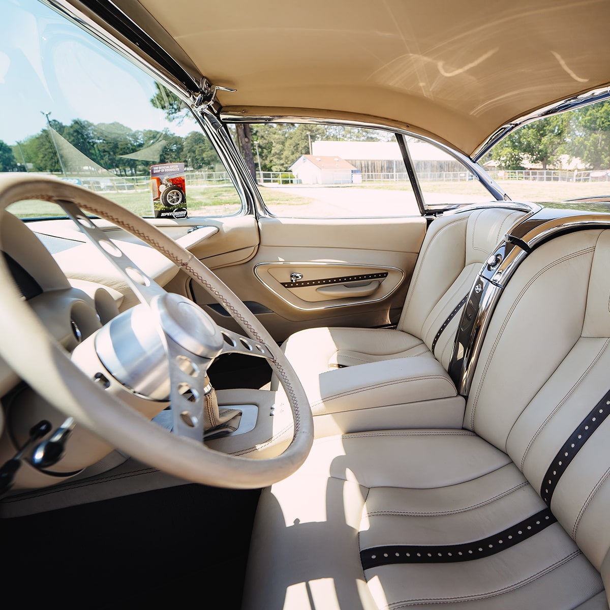 Driver's Side View of the Front Seat and Steering Wheel Inside a 1958 Chevrolet Corvette.