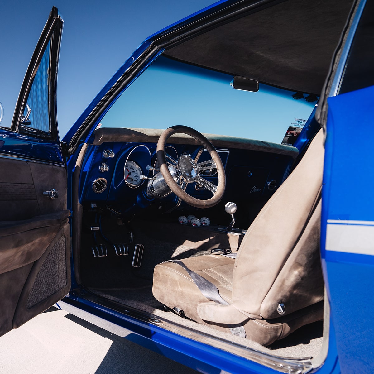 Driver's Side View of a 1967 Chevrolet Camaro SS with the Door Open Viewing the Tan Seat and Steering Wheel.