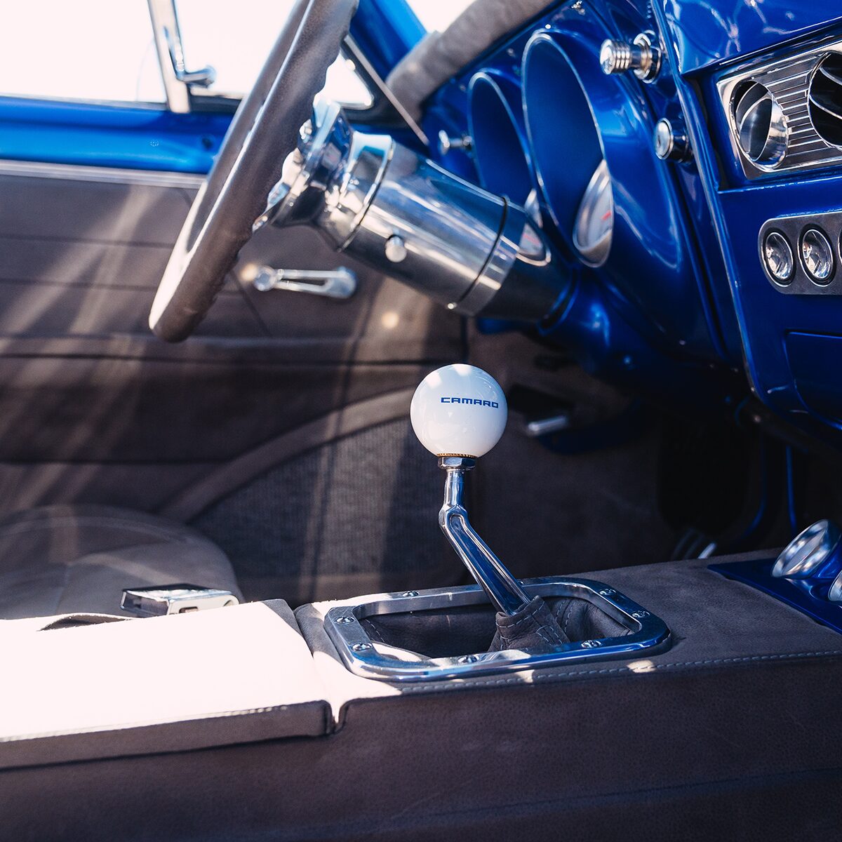 A Close-up View of the Gear Shift with a White Ball on Top Inside a Blue 1967 Chevrolet Camaro SS.