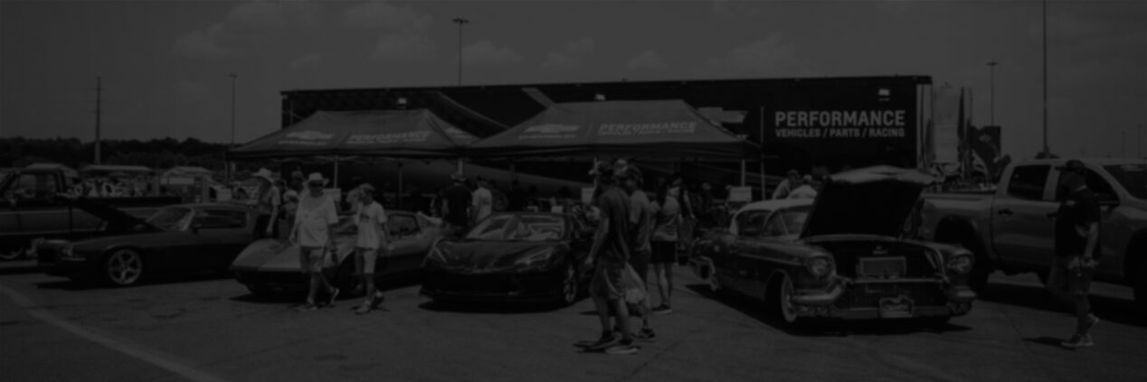 Exterior View of a Chevrolet Dealership with Classic Chevy Vehicles on Display in the Parking Lot and a Crowd of People