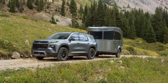 A Chevy SUV Tows a Trailer in the Countryside