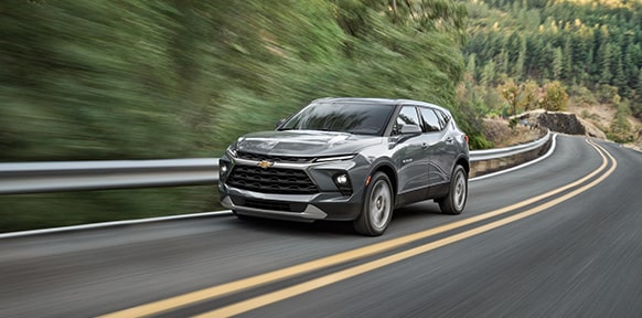 A Chevy SUV Drives Through a Mountainous Road