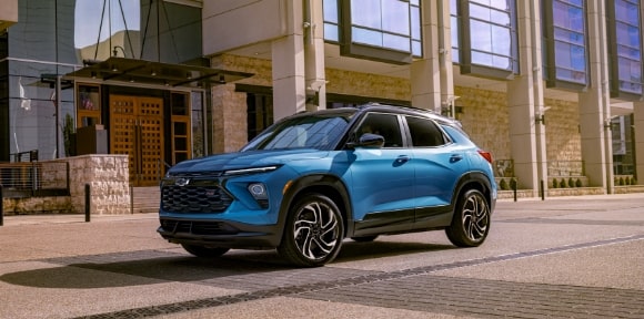 A Chevy SUV driving through city window building