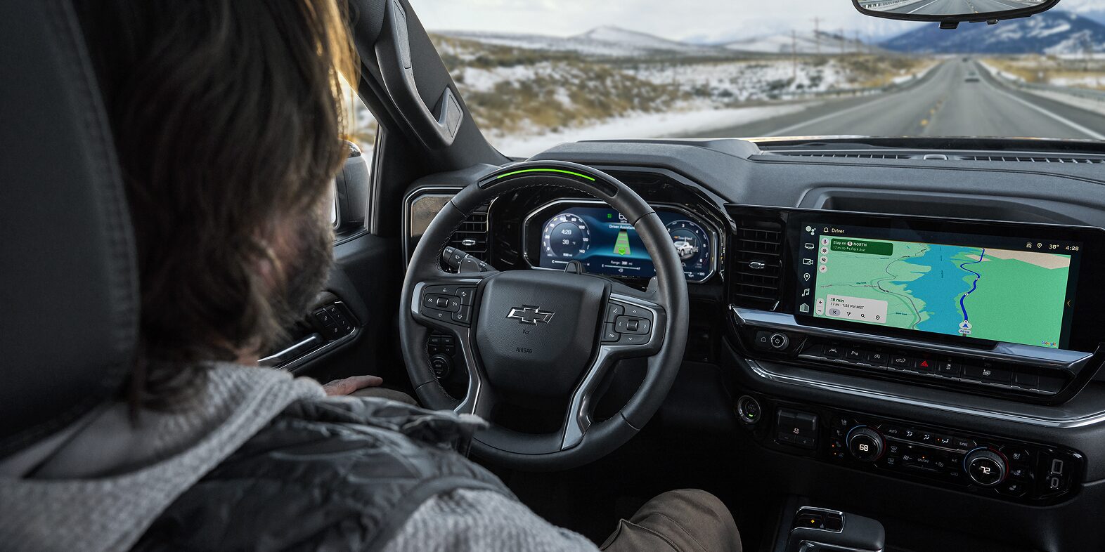 Man In Driver's Seat of Chevy Silverado Looking at Interior Dashboard