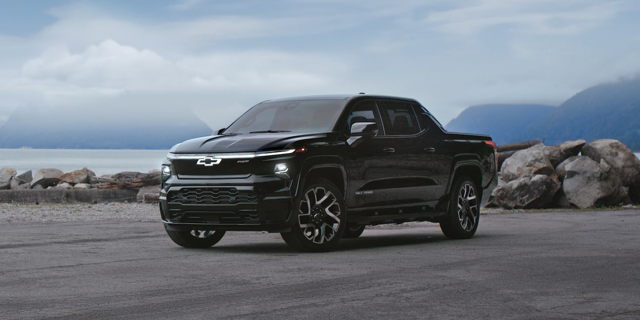 Chevy Silverado EV Parked in Front of Snowy Mountain