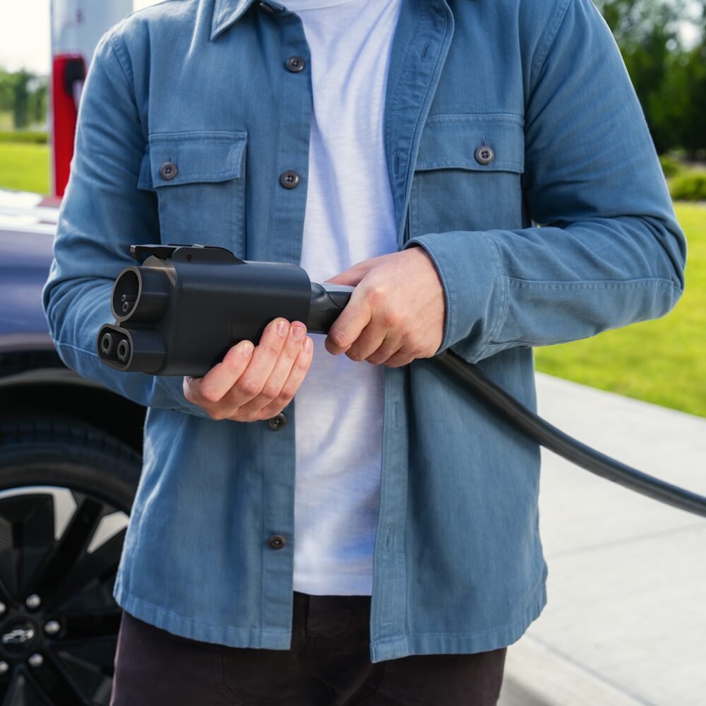 A Man Holding a Chevy EV Charger