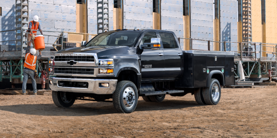Chevy Silverado Chassis Cab Parked with Construction Workers Loading the Bed with Materials 