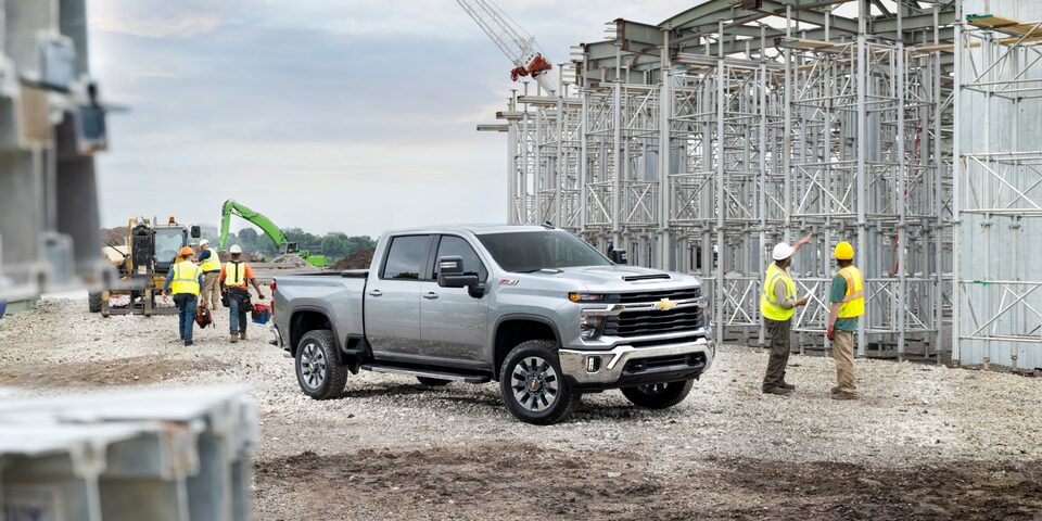 A 2025 White Chevy Silverado HD Truck in a Construction Site with Workers
