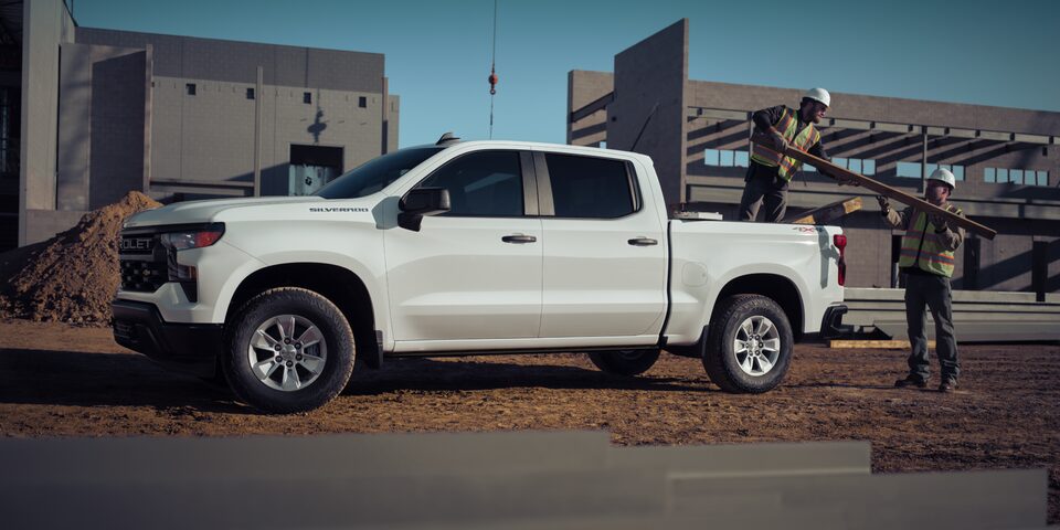 Two Construction Workers Unloading Materials From a 2025 Chevrolet Silverado Truck