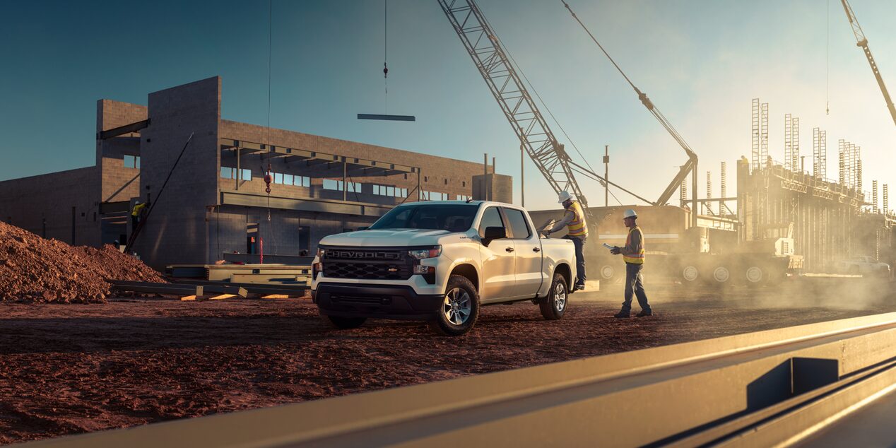 Two Construction Workers Standing Near a 2024 Chevrolet Silverado Truck