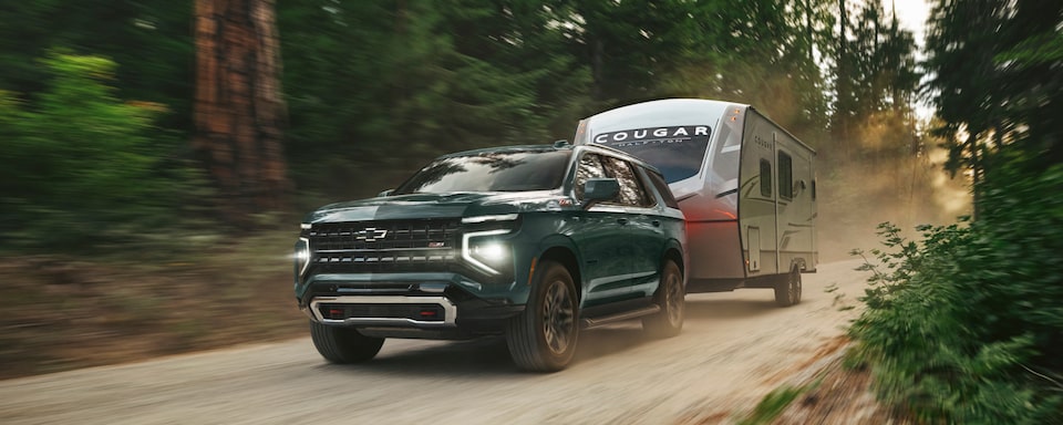 2025 Chevy Tahoe Towing a Camper in the Woods