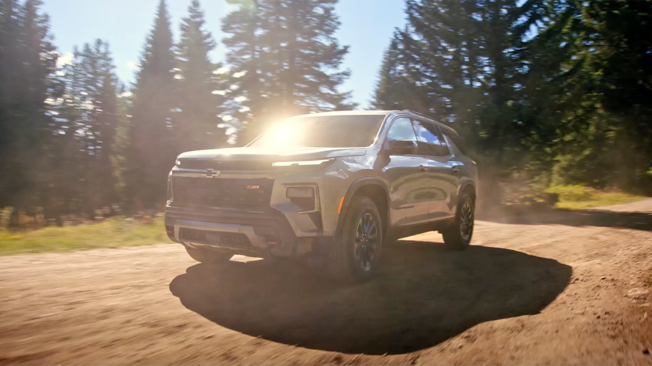Three Quarters View of a 2025 Chevy Traverse on the Road with Sunlight Hitting the Windshield