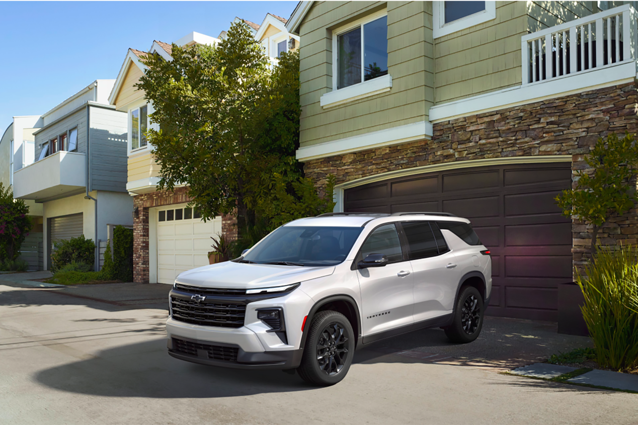 Three Quarters View of a 2025 White Chevy Traverse Coming Out of a Garage