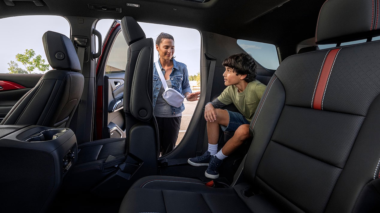 A Woman Opening the Back Door for Her Son to Get out of a 2025 Chevy Traverse