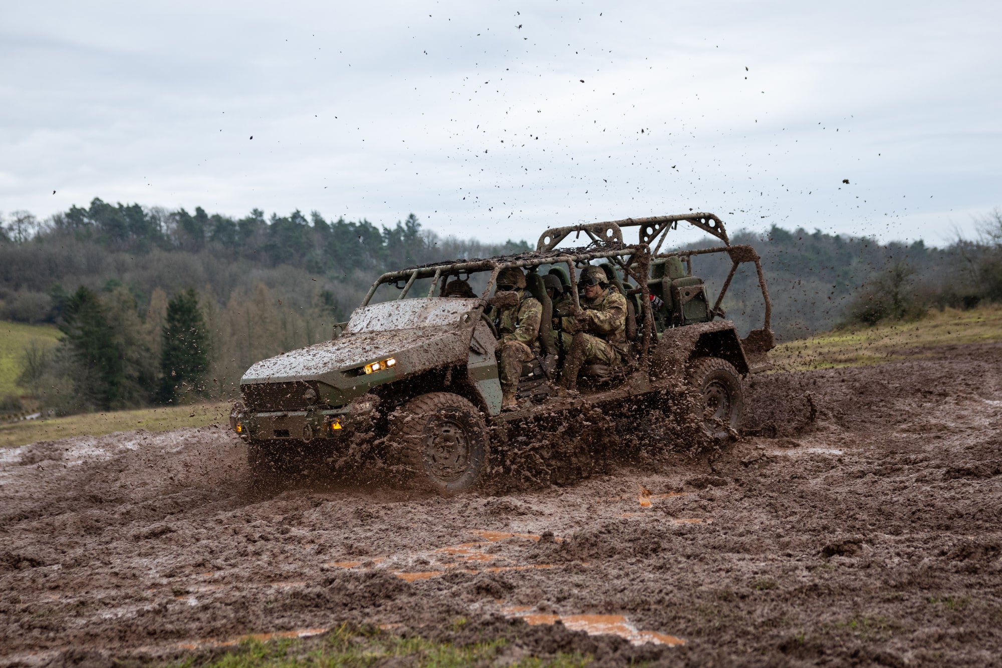 An Army Truck Full of Soldiers Driving Through a Muddy Terrain