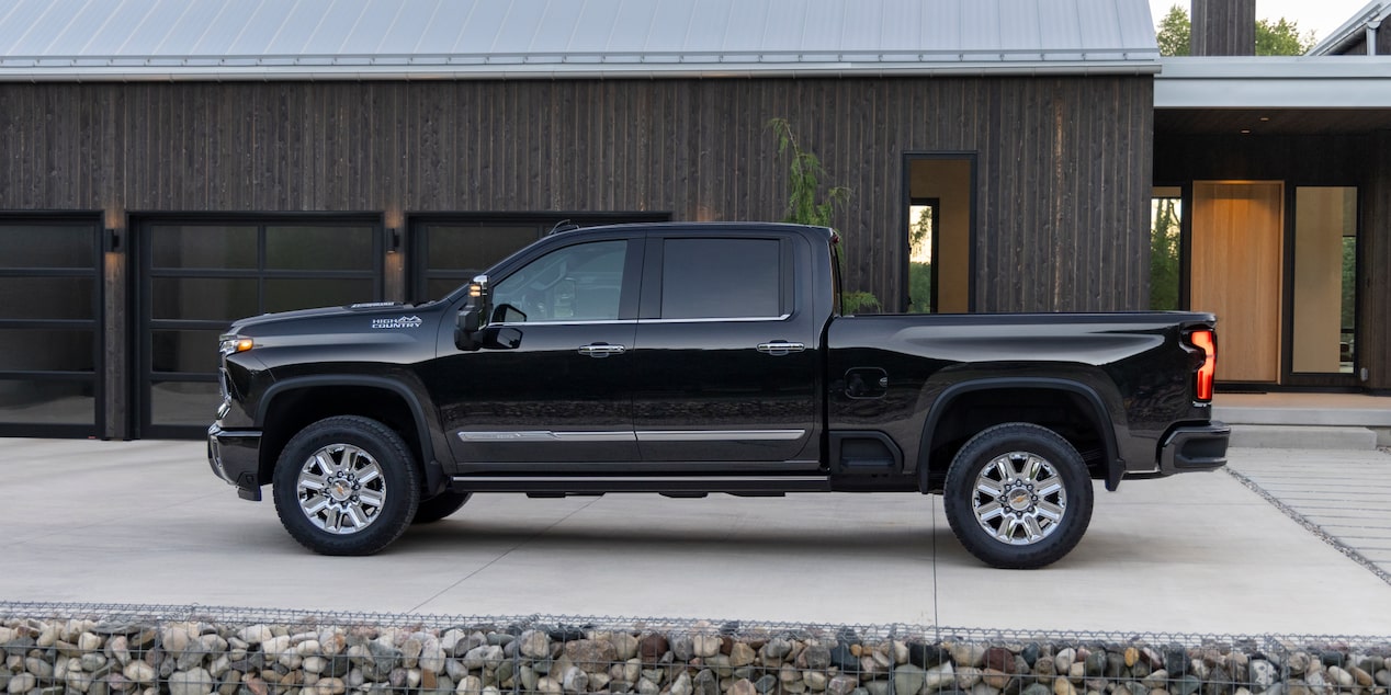 Side View of a Black 2025 Chevy Silverado HD Next to a House