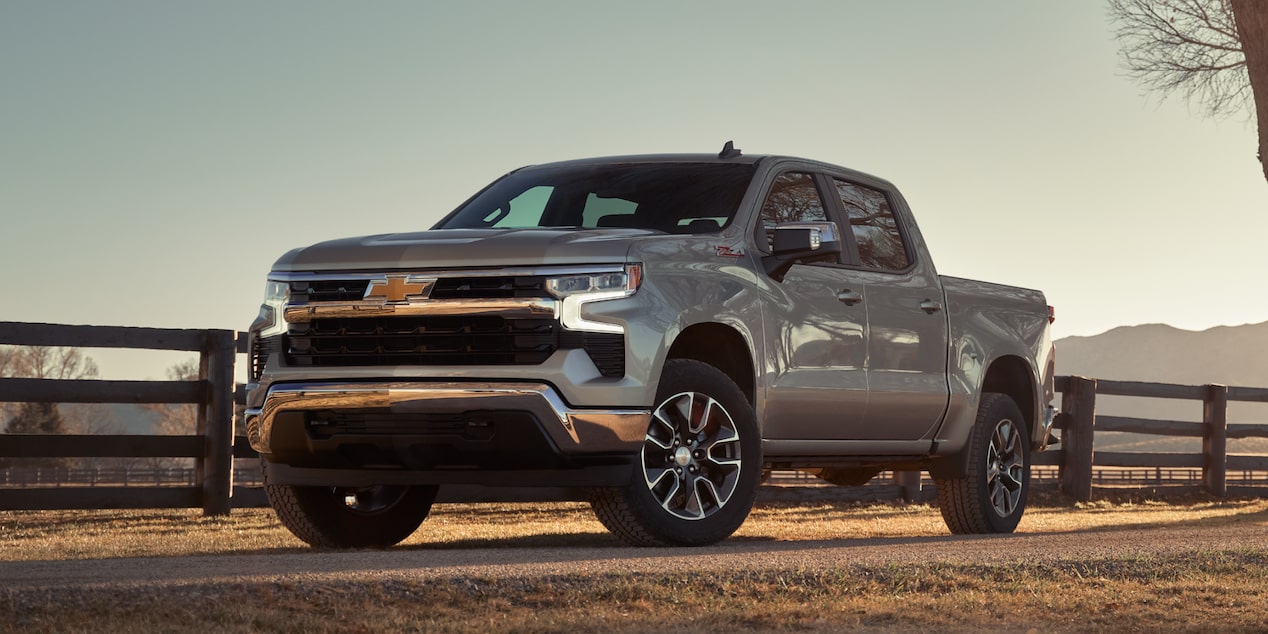 Three Quarters View of A Silver 2025 Chevy Silverado Pickup Truck with Sunlight Coming from the Back