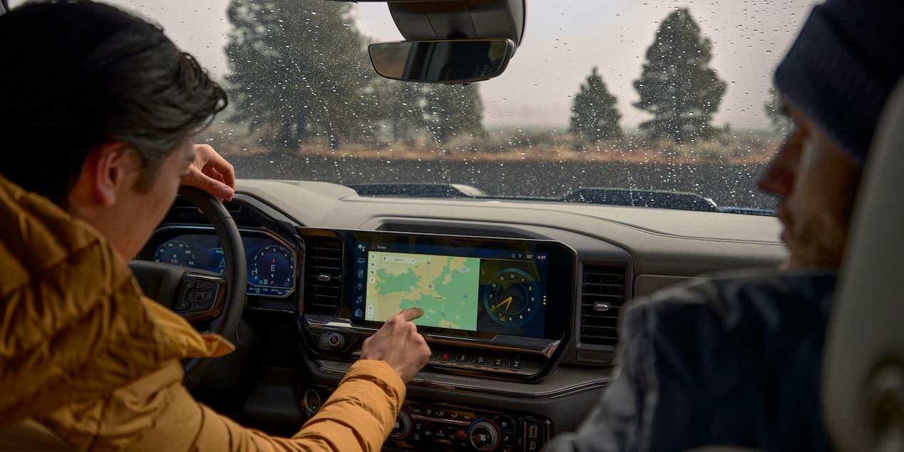 Two Men in the Front Seats of Chevy Silverado Viewing the Map on the Display Board