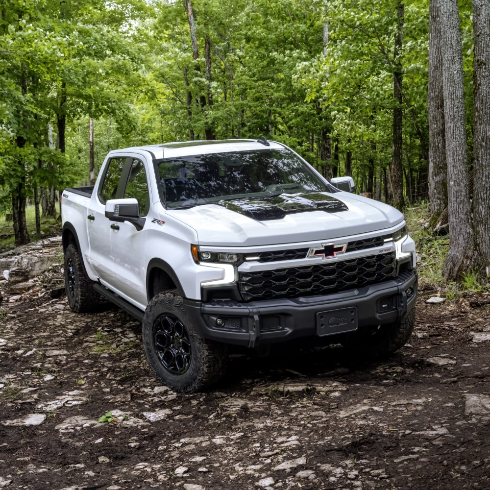Three Quarter View of a 2025 White Silverado Going Through a Jungle