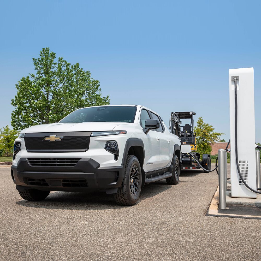 2026 Chevy Commercial Silverado EV Towing Construction Equipment While Parked at a Charging Station