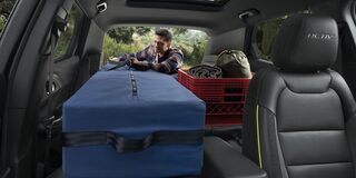 A Man Loading Camping Gear Inside the Trunk of the 2026 Chevy Trailblazer