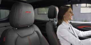 A Woman Smiling While Driving Her 2026 Chevy Trailblazer