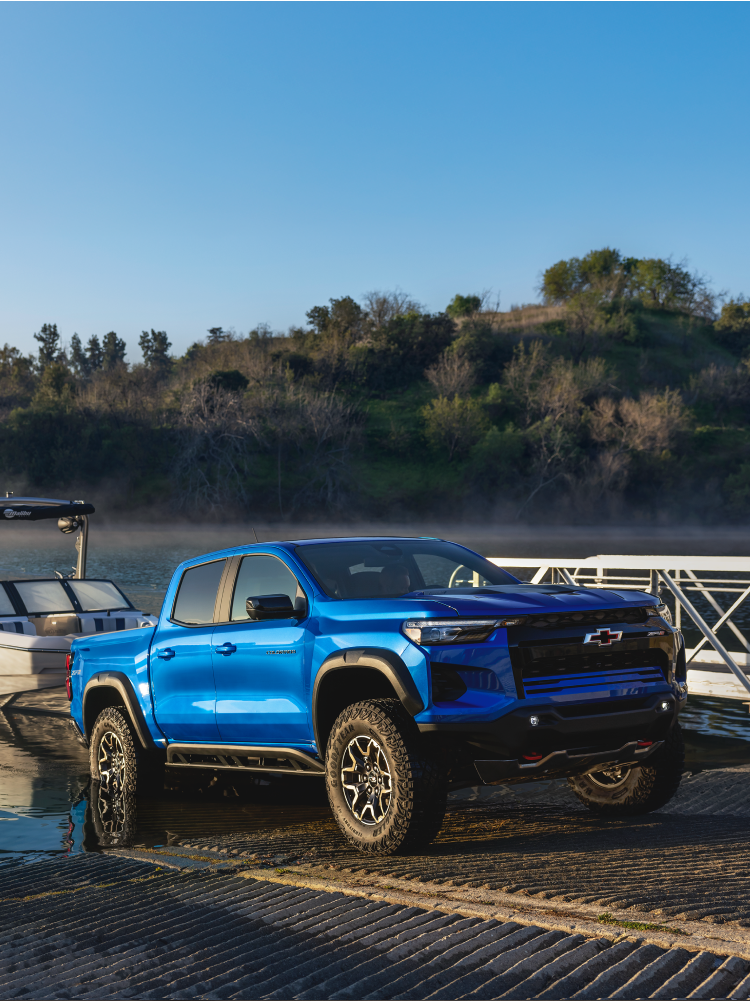 Three Quarters View of a 2026 Chevy Colorado Pickup Truck Pulling a Speed Boat to Shore