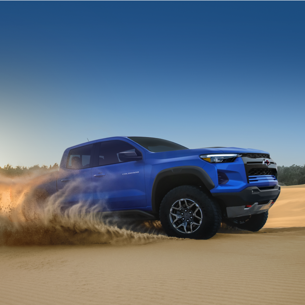 Three Quarters View of a Blue 2026 Chevy Colorado Pickup Truck Driving in the Desert