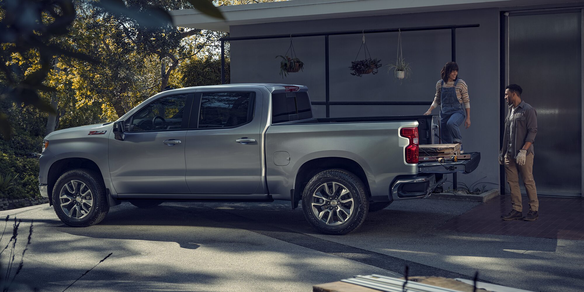 Side view of the 2026 Chevrolet Silverado LD Crew Cab LT parked beside a house.