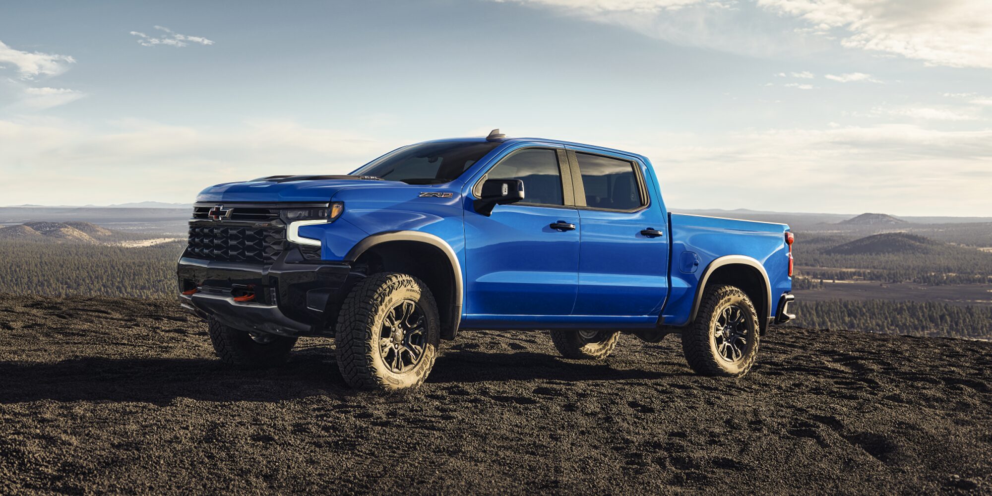 Side view of the 2026 Chevrolet Silverado LD Crew Cab ZR2 parked alone on a dirt terrain.