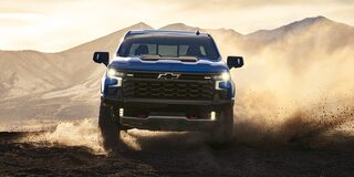 Front view of the 2026 Chevrolet Silverado LD Crew Cab ZR2 driving on a dusty terrain.