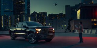 2026 Chevrolet Silverado LD Crew Cab parked outdoors at night.