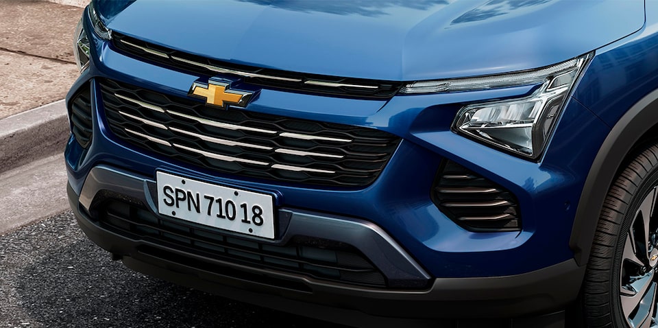 Imagem do novo Chevrolet Spin, na cor Azul Boreal, com foco nos faróis em LED, e na grade frontal com detalhes cromados.