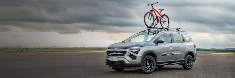 Chevrolet Spin MY25 na cor cinza com uma bicicleta em cima do carro com o suporte de bicicleta