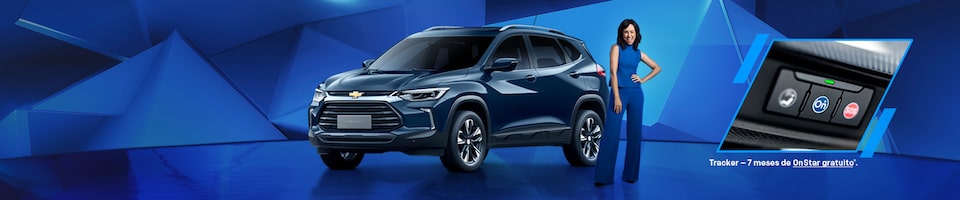 Um Chevrolet Tracker azul com uma mulher parada ao lado, mostrando um close do botão do Onstar.
