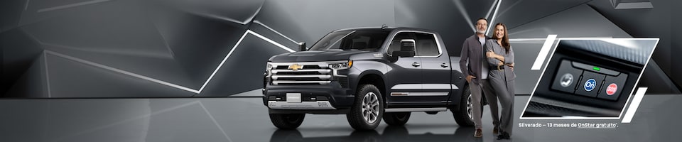 Um Chevrolet Silevrado azul com uma mulher parada ao lado, mostrando um close do botão do Onstar.