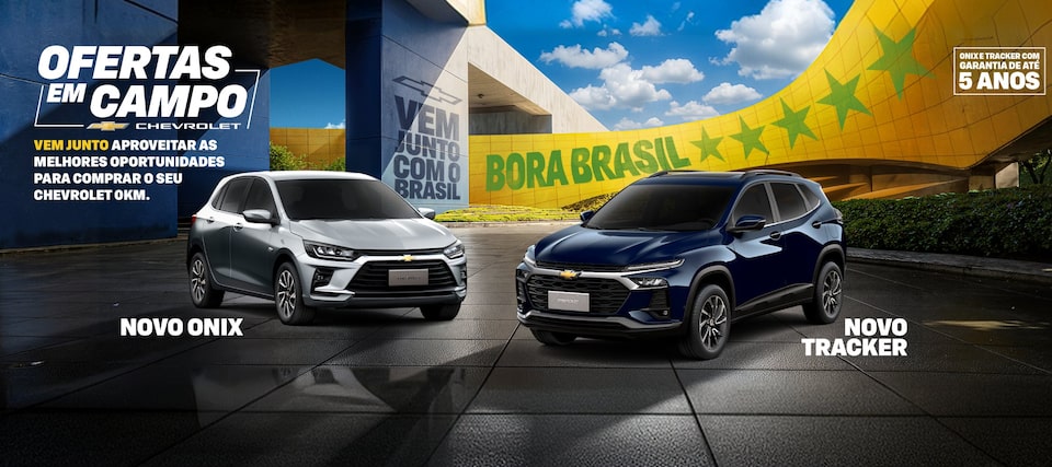 Chevrolet Ofertas em Campo com os modelos Novo Onix prata e Novo Tracker azul em destaque. Ao fundo, arquitetura moderna com faixa verde e amarela escrita Bora Brasil e mensagem sobre condições especiais para compra de veículos Chevrolet 0 km, com garantia de até 5 anos.